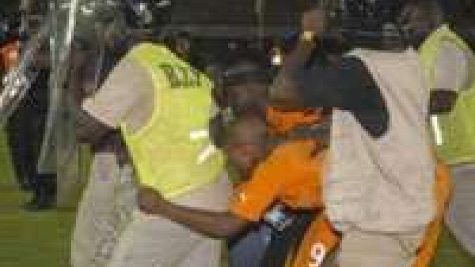 Giocatori ivoriani scortati dalla polizia negli spogliatoiIl calcio dei feriti